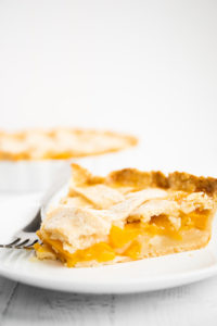 slice of peach pie on a plate